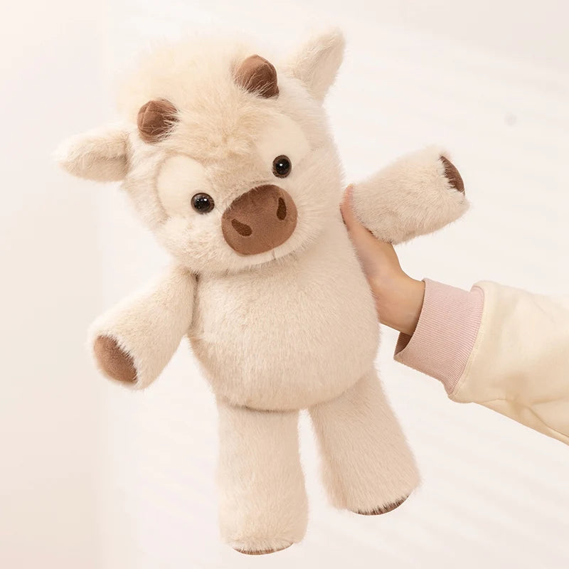Hand holding the cow plush by the head