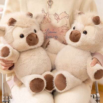 Close-up of two fluffy cow plushies being hugged